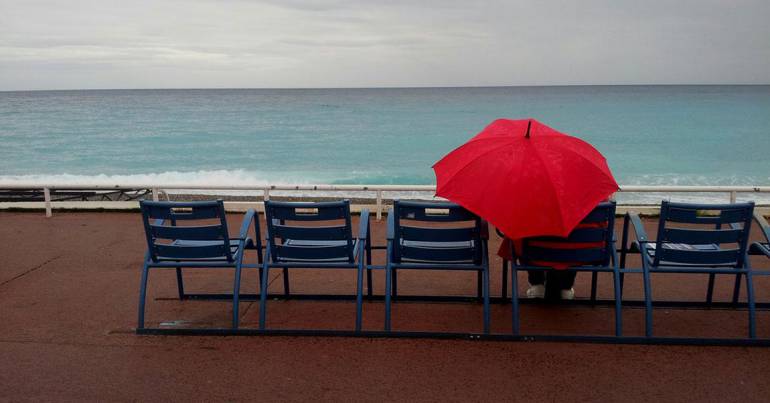 femme parapluie sur les chaises bleues de la promenade des Anglais